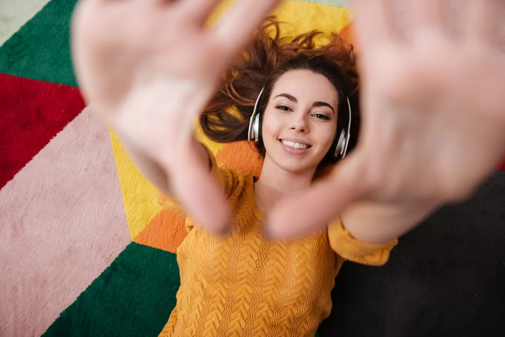 portrait-of-a-young-smiling-girl-in-headphones-enjoying-music