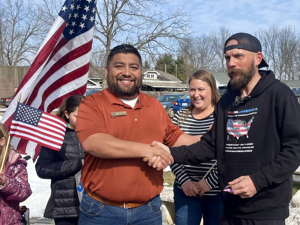 Crowd welcomes cross-country runner as he passes through Cass County