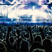 The crowd in a fan zone in a concert hall. Raised hands during a music show