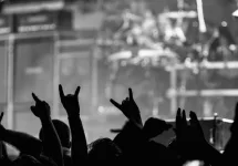 crowd holding up fingers in 'rock on' signs at rock concert/silhouette