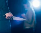 cropped-view-of-killer-holding-knife-near-woman-on-black