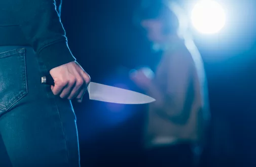 cropped-view-of-killer-holding-knife-near-woman-on-black