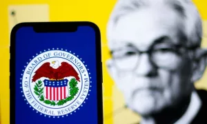 in this photo the logo Federal Reserve System^ The Fed with the Chair Jerome Powell in the background.