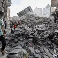 People search the Khan Yunis municipality building after an Israeli air strike^ in the city of Khan Yunis^ southern of the Gaza Strip^ October 10^ 2023.