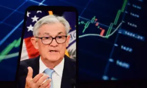 On the smartphone screen^ Federal Reserve (Fed) Chair Jerome Powell is visible. In the background^ an inflation rate chart is displayed. 19.04.2025. New York^ U.S