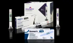 Injection pens and packaging boxes of weight-loss and type 2 diabetes medication Mounjaro^ Wegovy^ Ozempic^ Zepbound Isolated on black background with reflections.