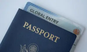Global Entry card (Trusted traveller) covered of Passport of United states on white background.