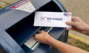 A man puts an absentee mail-in ballot in the mailbox. Circa August^ 2020