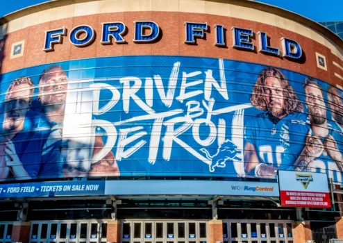 Closeup of "Ford Field" Detroit Lions' football field stadium's exterior facade brand and logo signage on a sunny day.