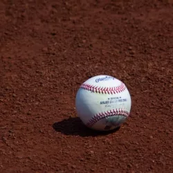 used Major League Baseball baseball sits on the warning track during a game between the Oakland Athletics and New York Yankees at RingCentral Coliseum. Oakland^ California - August 28^ 2021