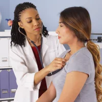 african-american-doctor-listening-to-heart-and-lungs-of-asian-patient