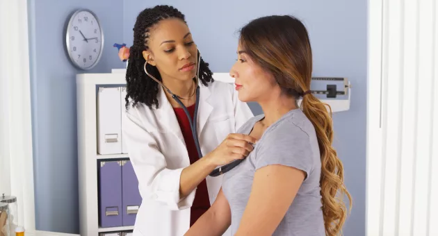 african-american-doctor-listening-to-heart-and-lungs-of-asian-patient