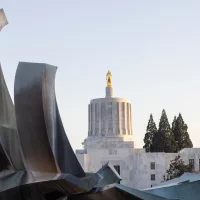 salem-or-usa-apr-2-2022-the-oregon-state-capitol-viewed-from-the-capitol-fountain-an-outdoor-cast-bronze-fountain-and-sculpture-in-the-oregon-state-capitol-park-in-salem-at-dusk