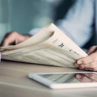 businessman-reading-the-newspaper-on-table