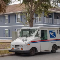 usps-mail-truck-delivering-mail-in-neighborhood-kissimmee-fl-usa-2-10-24