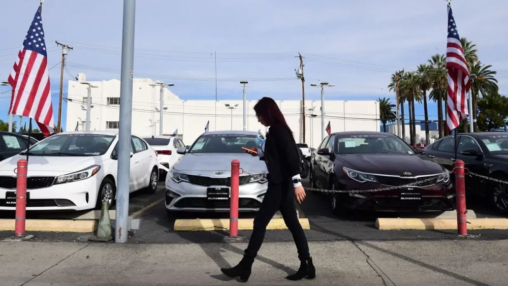 a-pedestrian-walks-past-a-certified-pre-owned-car-sales-lot-in-alhambra-california598131