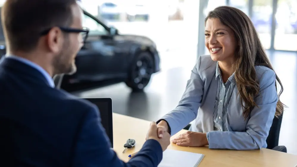 car-dealership-or-documents-with-salesman-and-customer-in-showroom-for-conversation-deal-or-offer-contract-finance-or-insurance-with-agent-and-woman-in-discussion-for-vehicle-purchase376375