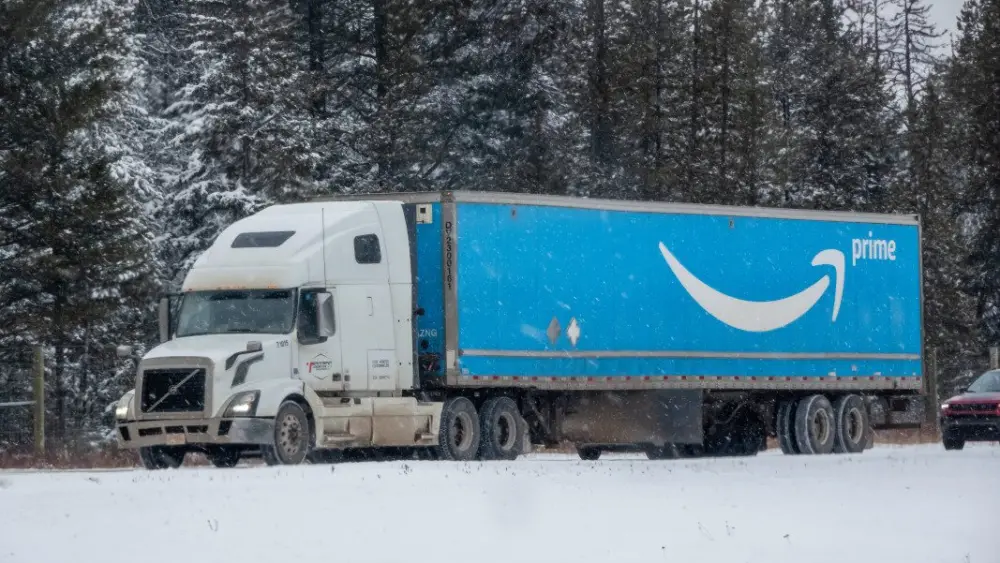 banff-alberta-canada-mar-31-2025-a-white-semi-truck-with-a-bright-blue-amazon-prime-trailer-drives-on-a-snowy-road-through-a-forest-stockpack-gettyimages299351