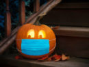 lighted-halloween-pumpkin-jack-o-lantern-wearing-covid-ppe-mask-on-steps