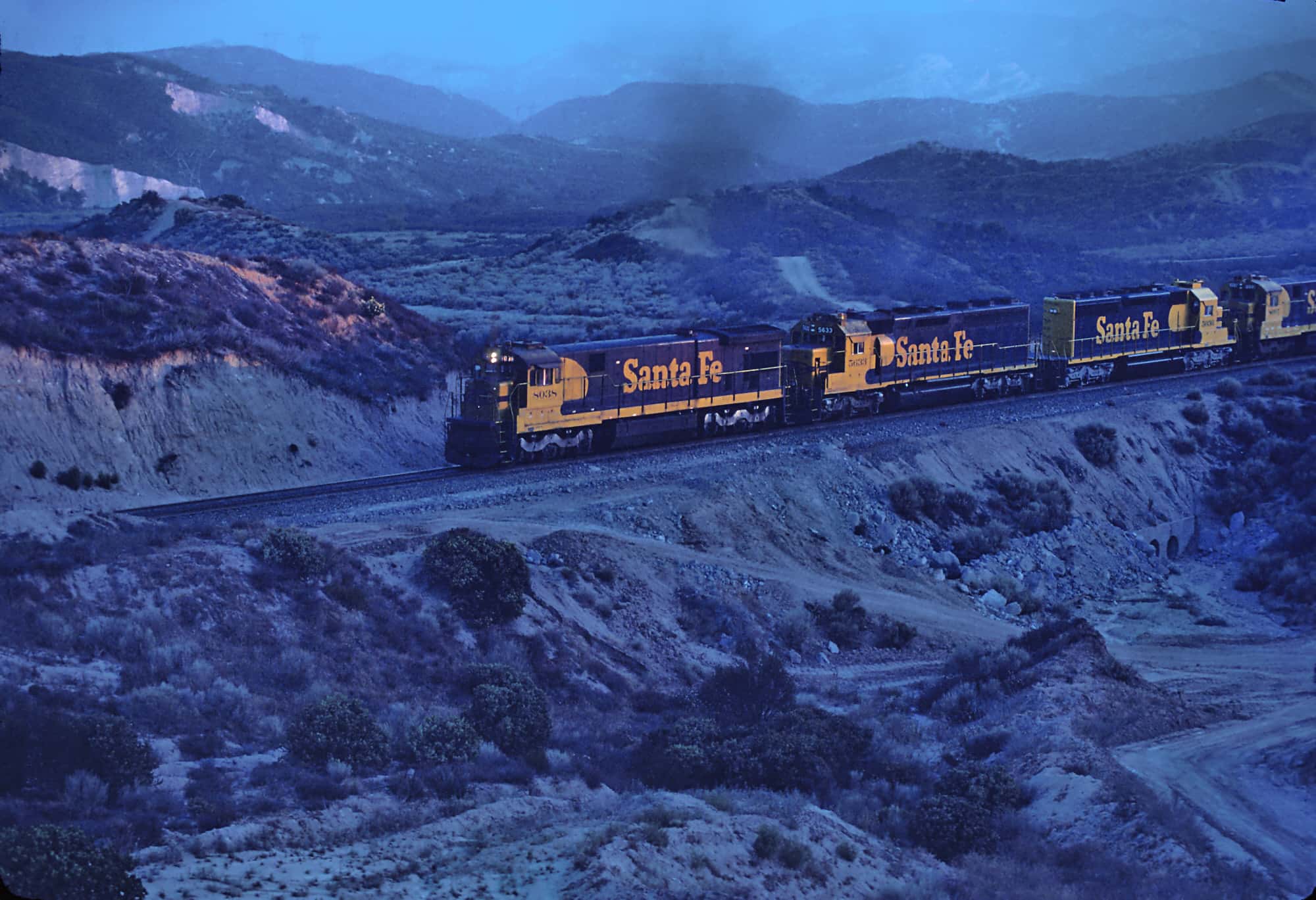 ATSF 8038 in Cajon Pass between Cajon station and Summit in a March 1981 blue hour KBRX 102.9 FM