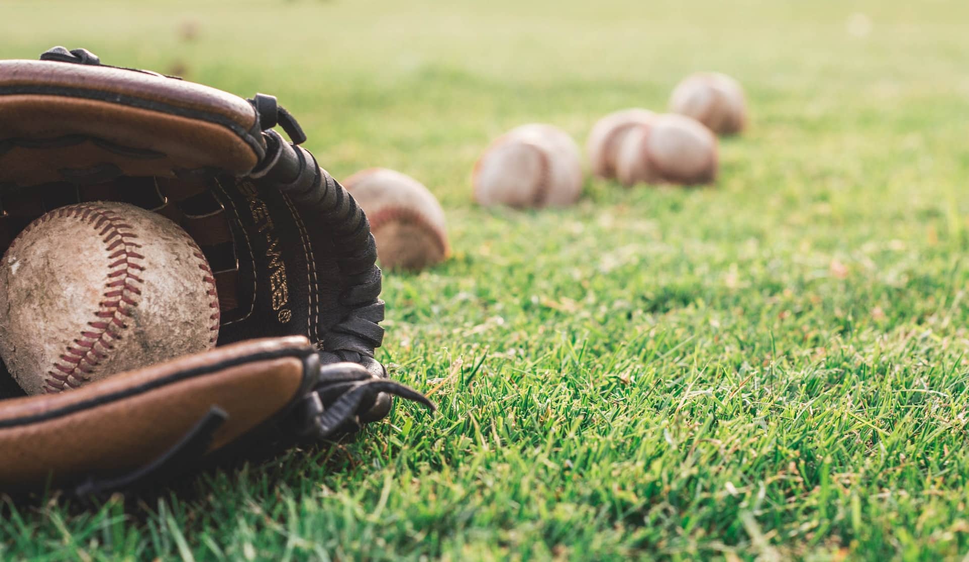 Skinny on Sports baseball story featured image. Glove and baseballs on ground
