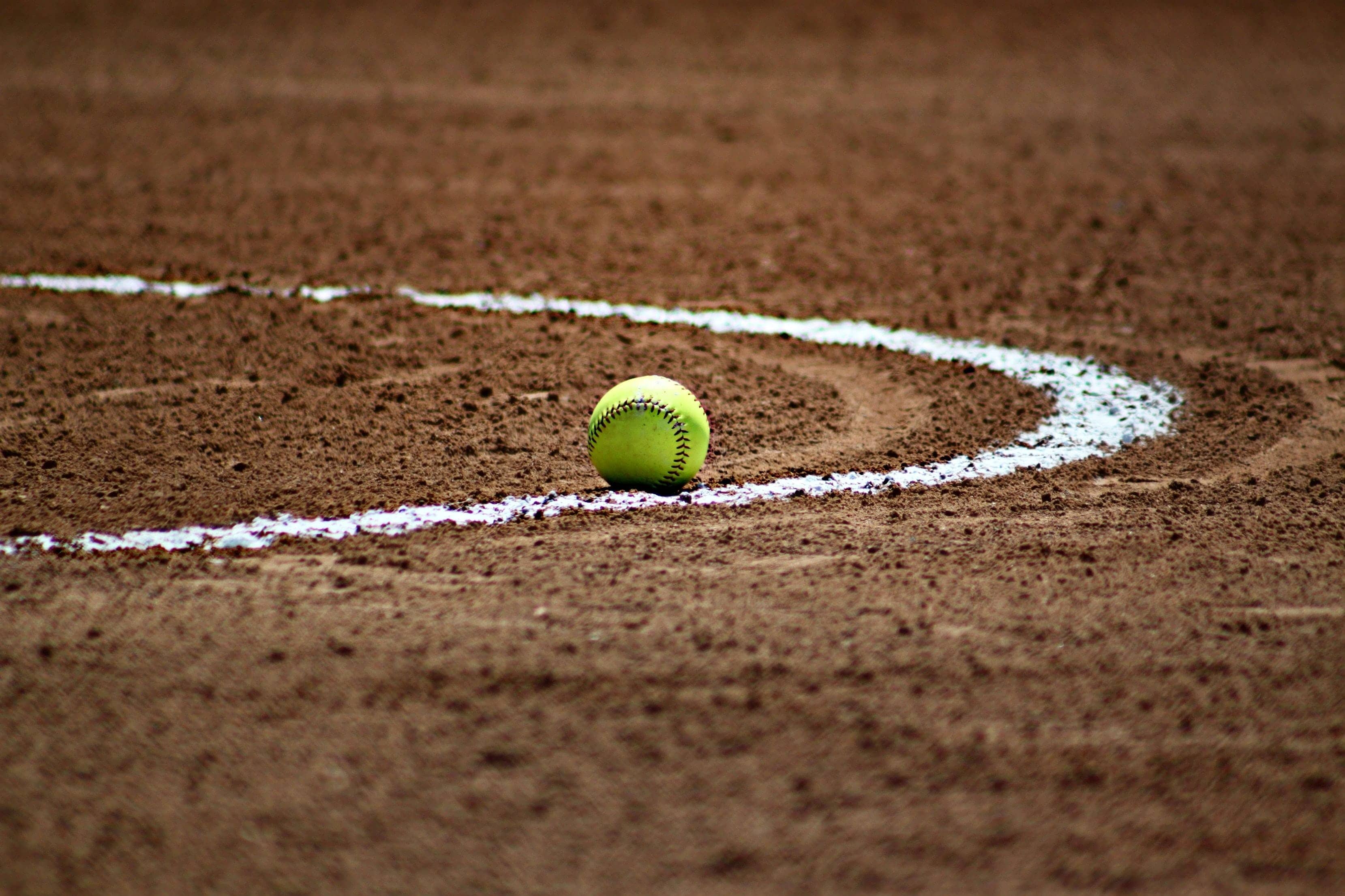 Close-up of a softball on a dirt softball field