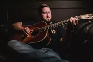 Jake Bush passionately playing his acoustic guitar