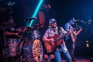 Jake Bush captivating the crowd with his acoustic guitar performance at a live concert