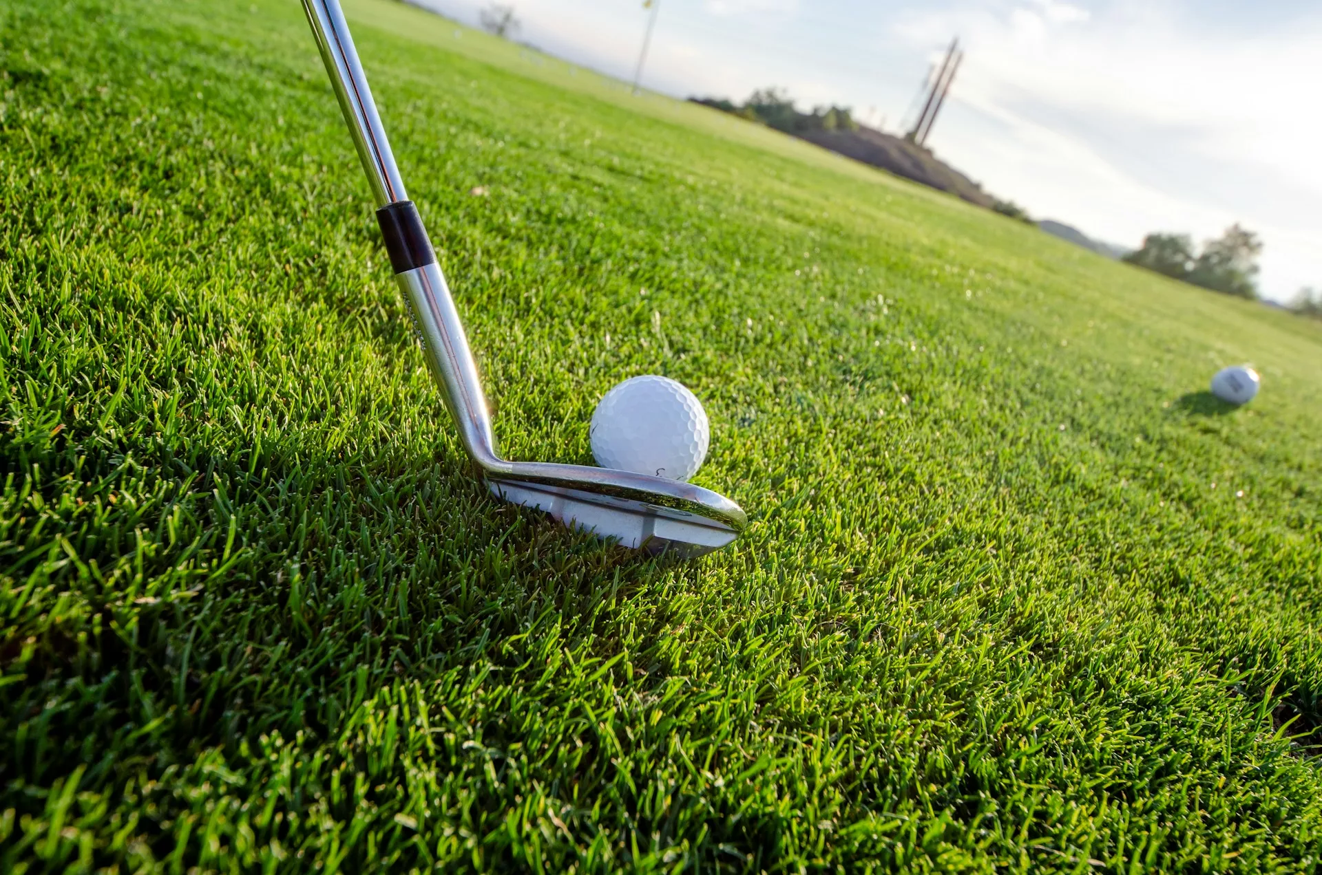 A golf club lined up to hit a ball on the course, symbolizing determination and skill.