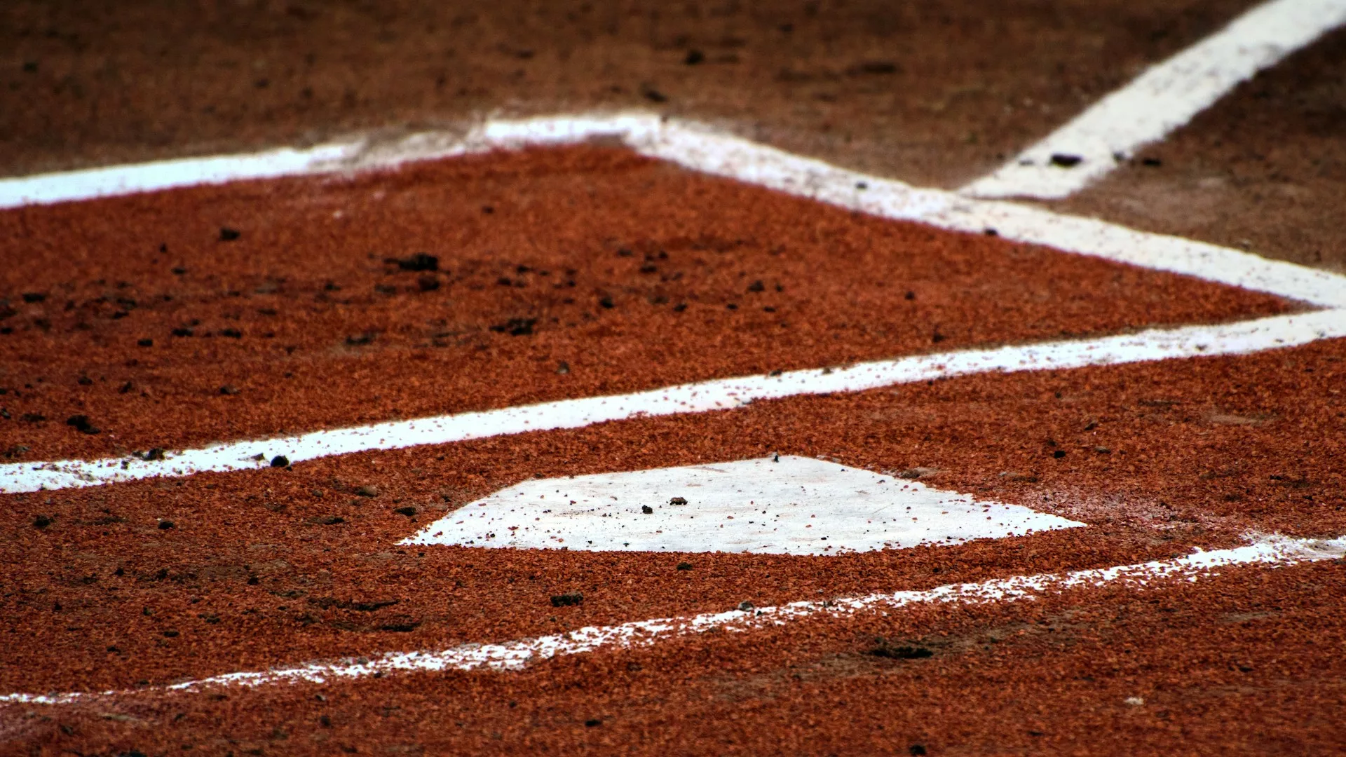 Home plate with red dirt and the batter's box, symbolizing the intensity of high school baseball playoffs.
