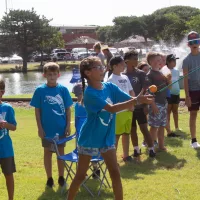 Kids participating in the 2023 Fishing Derby casting contest at Ackley Park.