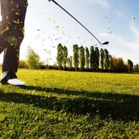 Golfer performing a powerful golf shot on a sunny day.