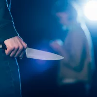 cropped-view-of-killer-holding-knife-near-woman-on-black