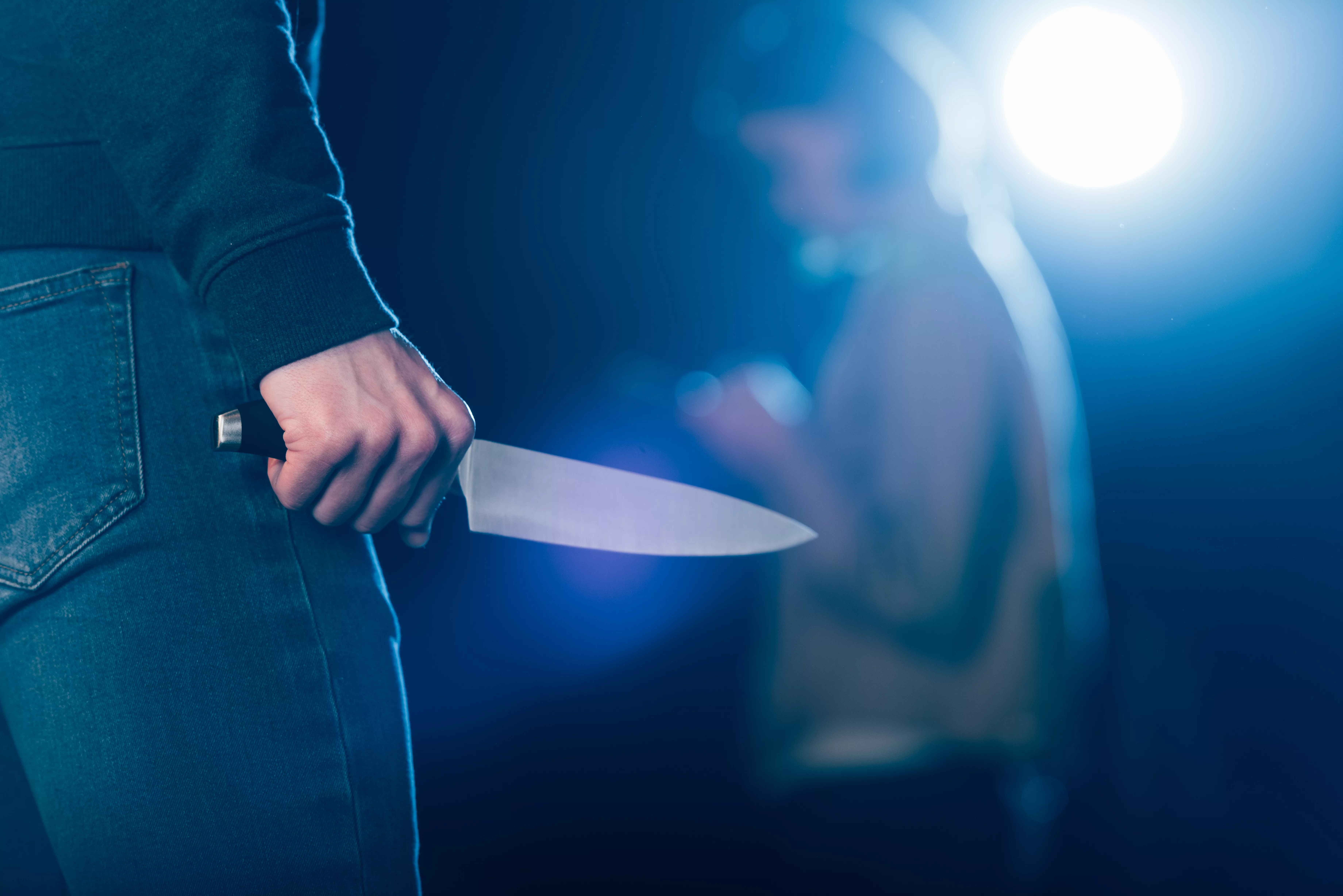 cropped-view-of-killer-holding-knife-near-woman-on-black