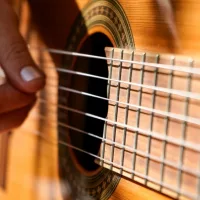 Closeup of hand of woman plays an acoustic guitar.