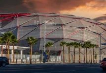 The Intuit Dome with cars driving on the street^ lush green palm trees and powerful clouds at sunset in Inglewood California USA. Inglewood^ California USA - 10 22 2024