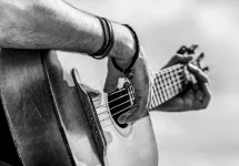 Acoustic guitars playing. Music concept. Black and white. Male musician playing guitar^ music instrument. Man's hands playing acoustic guitar^ close up.