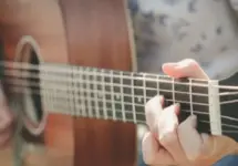 close of of hand playing guitar