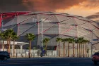 The Intuit Dome with cars driving on the street^ lush green palm trees and powerful clouds at sunset in Inglewood California USA. Inglewood^ California USA - 10 22 2024