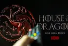 House of the Dragon HBO TV series on TV with remote control in hand. Focuse on the tv screen. Story takes place 300 years before events portrayed in Game of Thrones