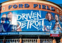 Closeup of "Ford Field" Detroit Lions' football field stadium's exterior facade brand and logo signage on a sunny day.