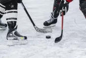 close-up of hockey puck^ sticks^ two players on ice during the game