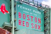 view of the historic architecture of the Famous Fenway Park Stadium in Boston^ MA^ USA showcasing its huge sign^ old brick walls^ and entrances on Lansdowne street. Boston^ MA^ USA - March 1^ 2023