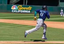 Seattle Mariners infielder Carlos Santana runs to first base against the Oakland Athletics at the Oakland Coliseum. Oakland^ California - August 21^ 2022