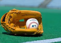Official Major League Baseball ball and glove on the green field ^ product shot