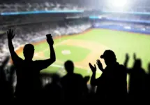 Baseball fans and crowd cheering in stadium and watching the game in ballpark. Happy people enjoying a match and sport event in arena. Friends watching ballgame live.