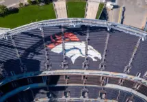 Denver Broncos Logo in Empty Stadium Seats at Empower Field. Aerial Top-Down View of NFL Branding and Architecture in Denver^ Colorado ay 26^ 2022 Denver^ Colorado