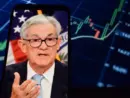 Federal Reserve (Fed) Chair Jerome Powell is visible. In the background^ an inflation rate chart is displayed.