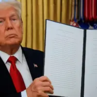 President Donald Trump signs executive orders in the Oval Office of the White House on January 20^ 2025 in Washington^ DC.