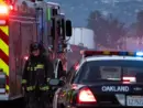 A firefighter stands outside a blaze at a transfer station in East Oakland. Two RVs caught fire in the enclosed lot. Oakland^ California - April 18^ 2026